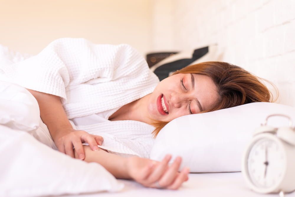 Asian woman sleeping on the bed and grinding teeth,Female bruxism,Gnash or clench your teeth